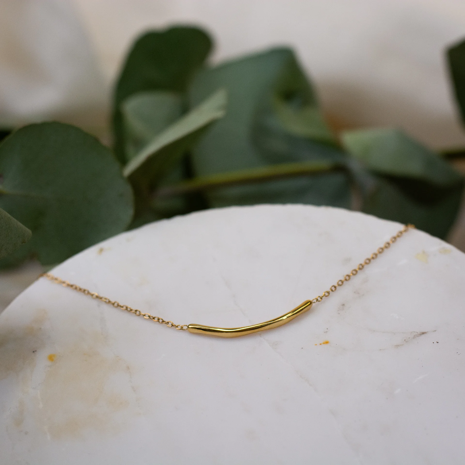 Amara Bracelet Gold 2 minimalistische gouden armband met uniek gebogen massief stukje van 2 cm elegant en aanwezig sieraad dat eenvoud en stijl uitstraalt luxe dames armband