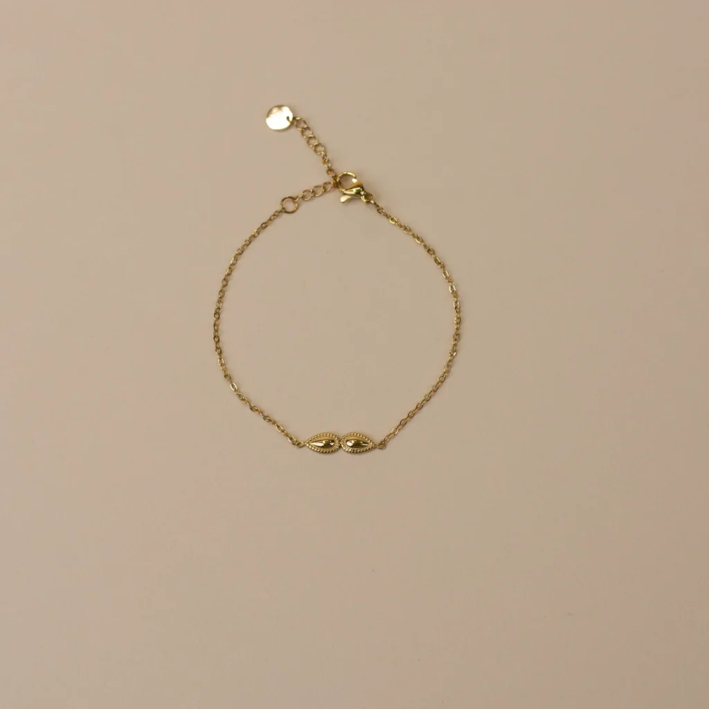 Esmé Bracelet Gold 2 minimalistische gouden armband met twee knopjes met reliëf bovenaanzicht op marmeren steen luxe dames sieraad